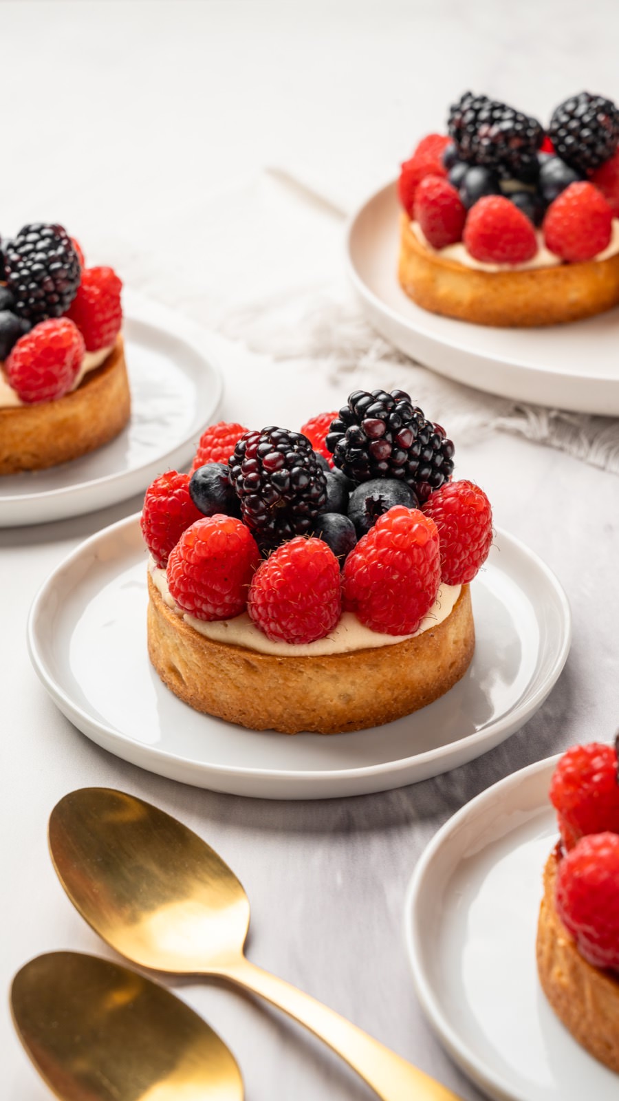 Tartaletas de frutas con frambuesas, moras y crema pastelera.