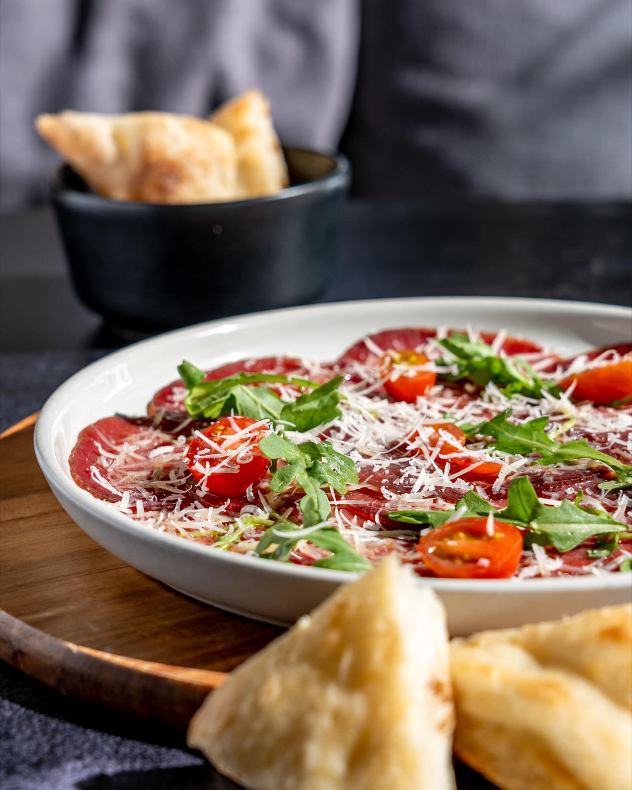 Carpaccio de res con rúcula, tomate cherry y queso parmesano.