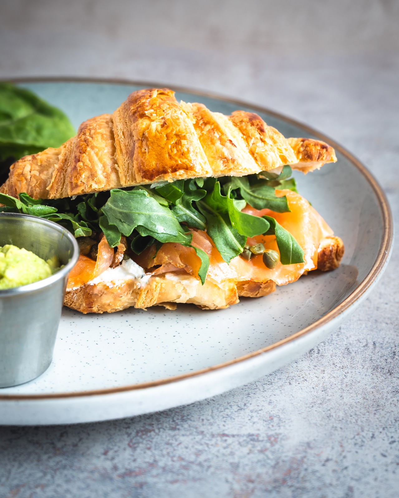 Croissant relleno  de salmon con vegetales frescos y aguacate.